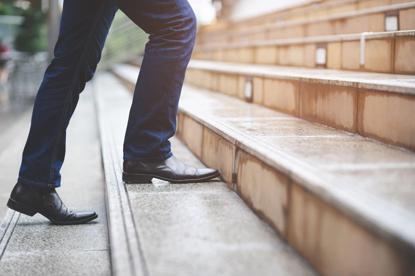 Young professional man walking up stairs.