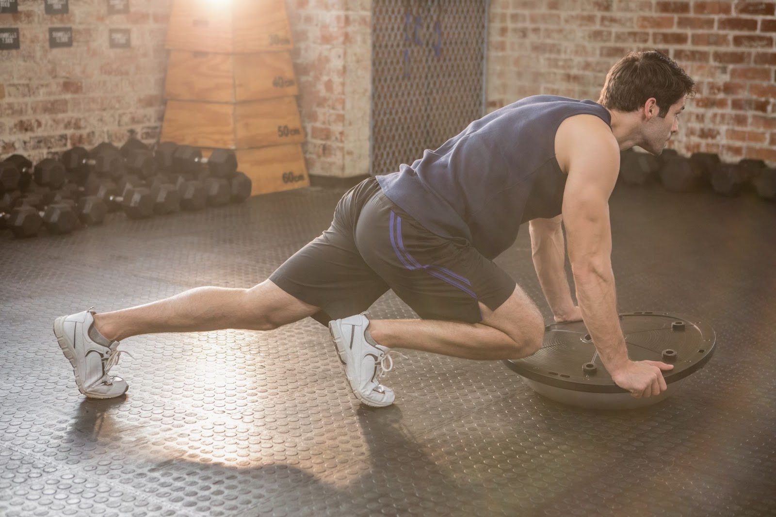 Man performing mountain climbers on a BOSU ball turned upside down.