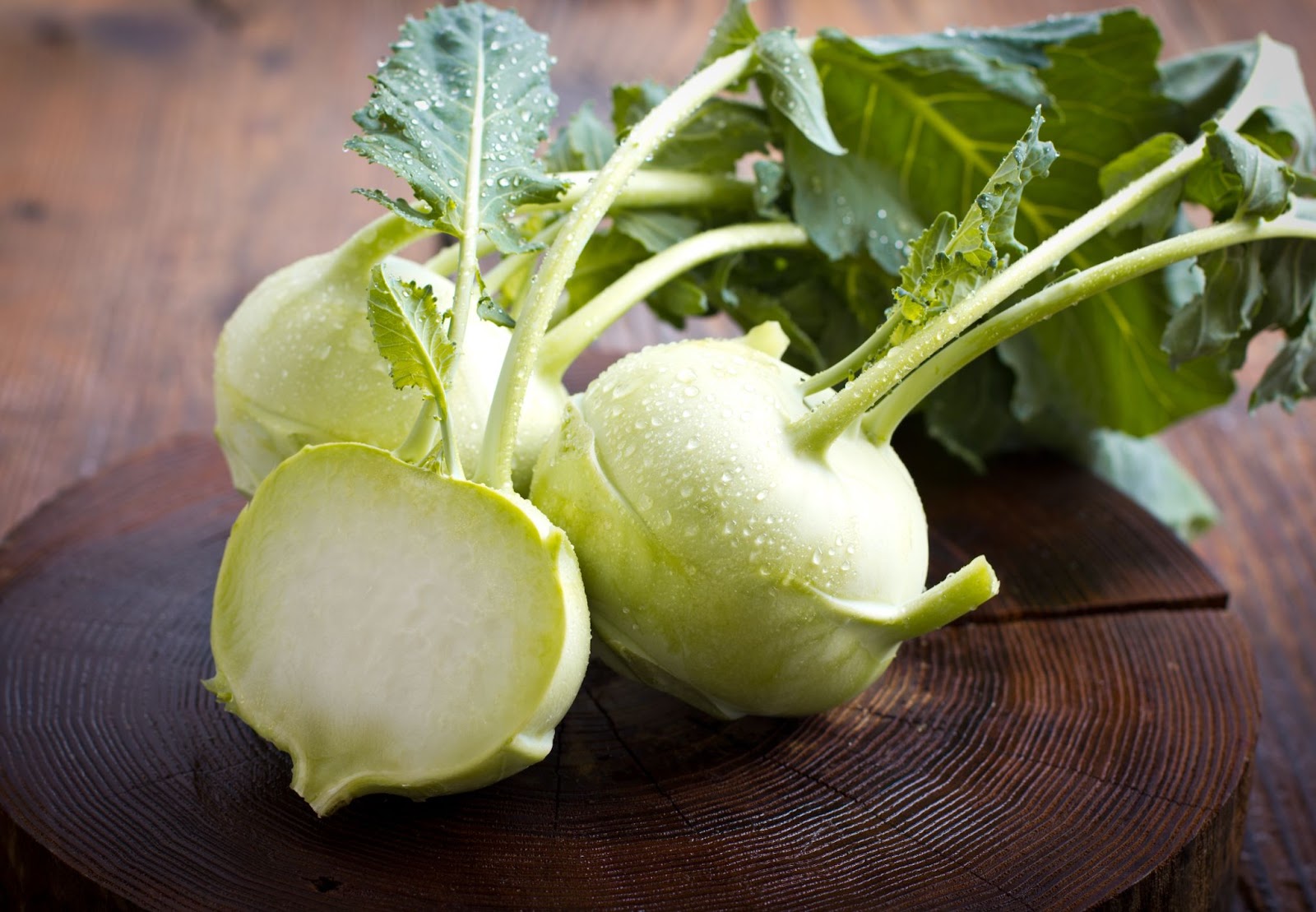 Sliced in half Kohlrabi on a wooden cutting board.