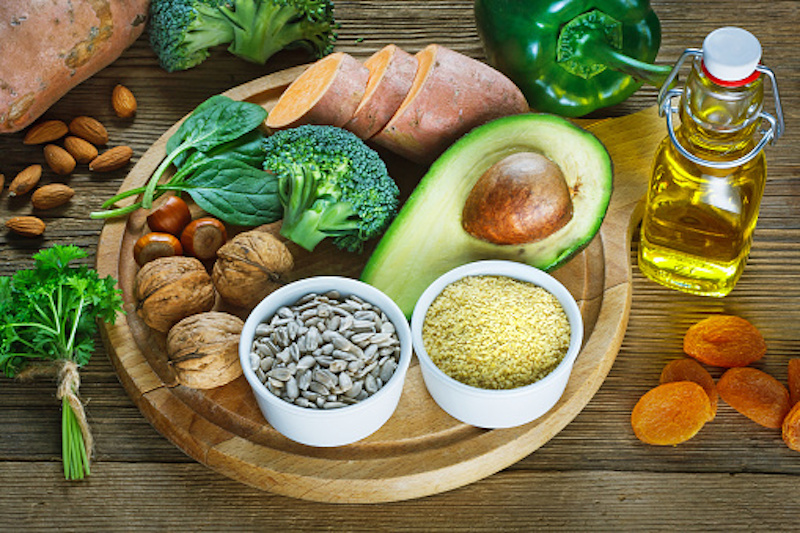 Healthy plate of food ingredients with avocado, broccoli, sweet potato, sunflower seeds and others