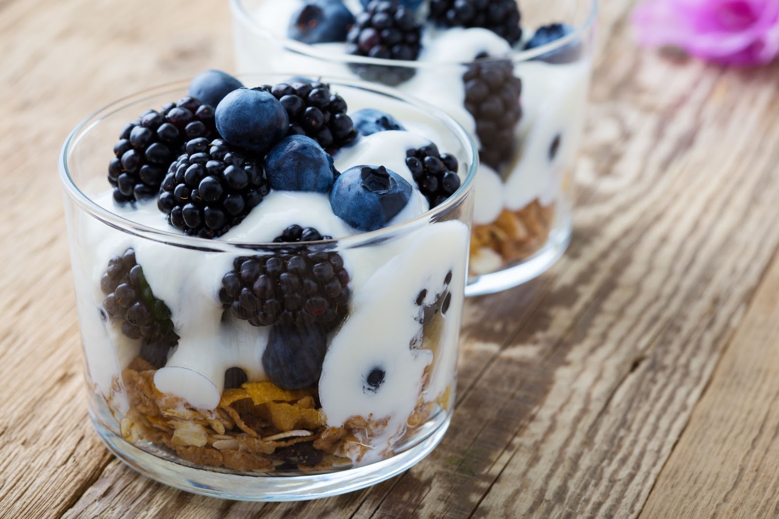 Greek yogurt in a glass mixed with berries and granola