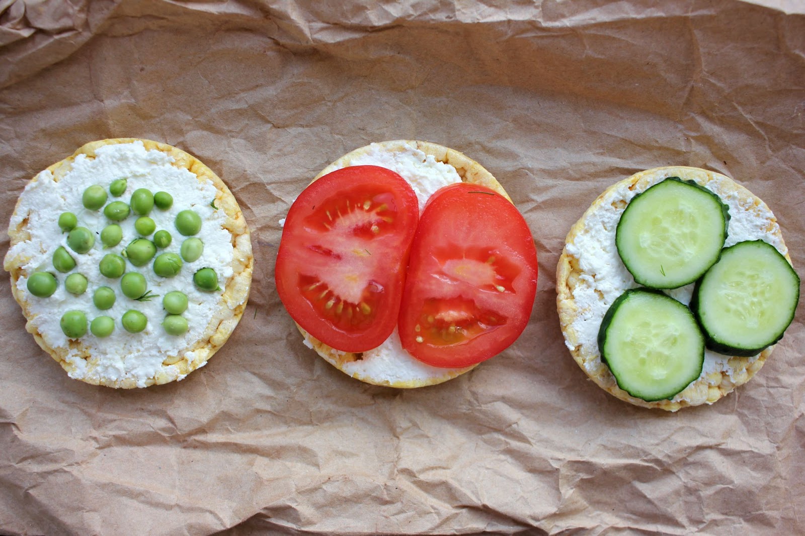 Three rice cakes topped with cottage cheese and different vegetables