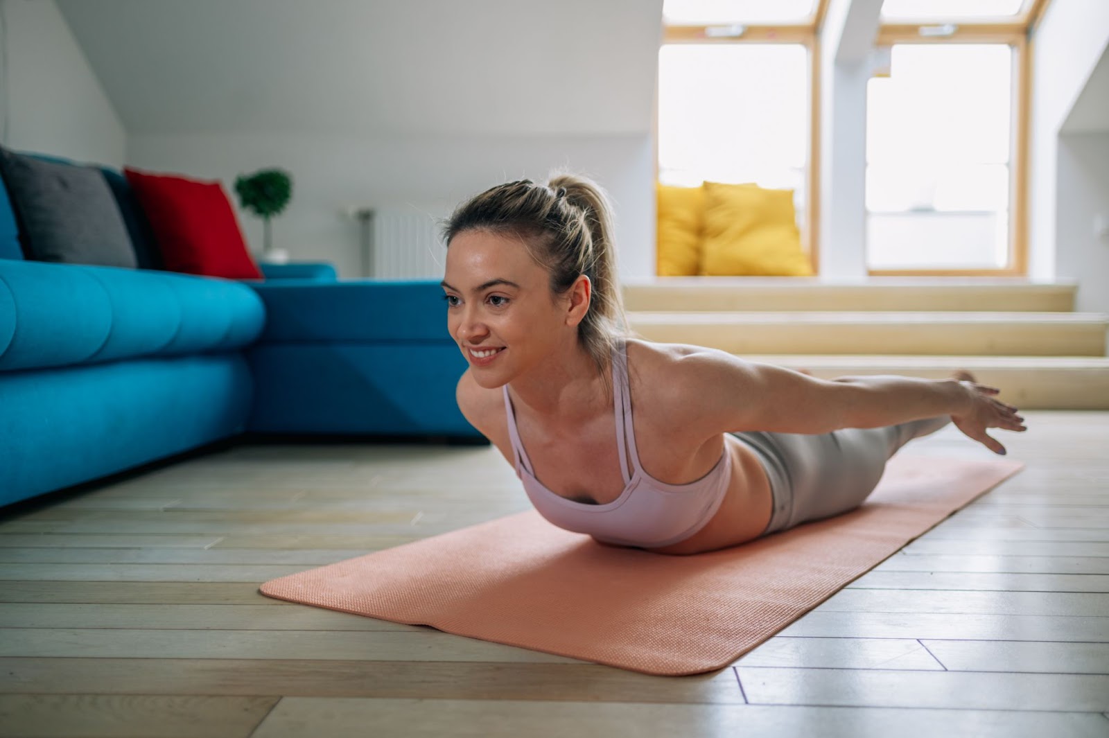 One woman smiling and performing a seal fitness routine