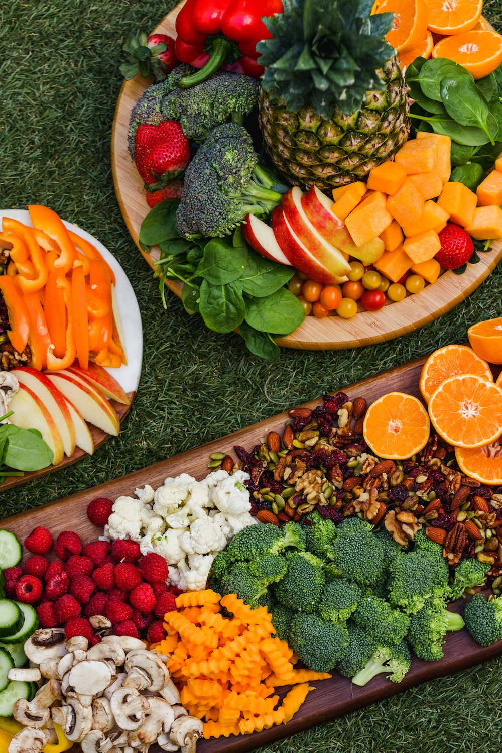 Picnic spread of fresh fruits and vegetables on a green lawn