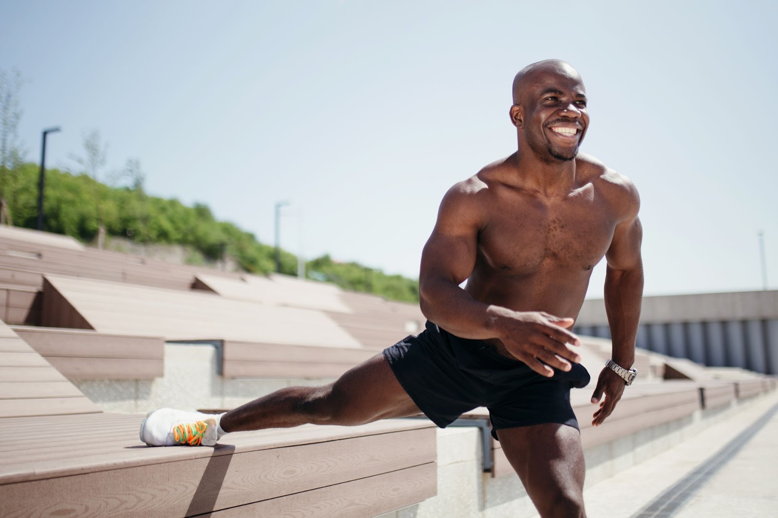 Fit young man stretching his adductor muscles outside