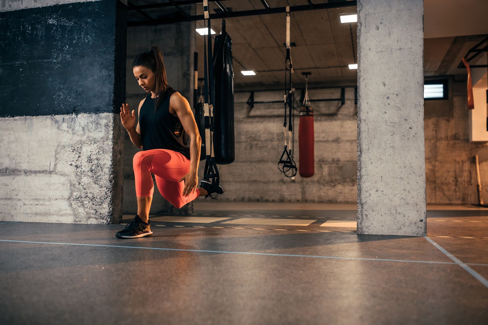 Woman doing a lunge using TRX suspension straps