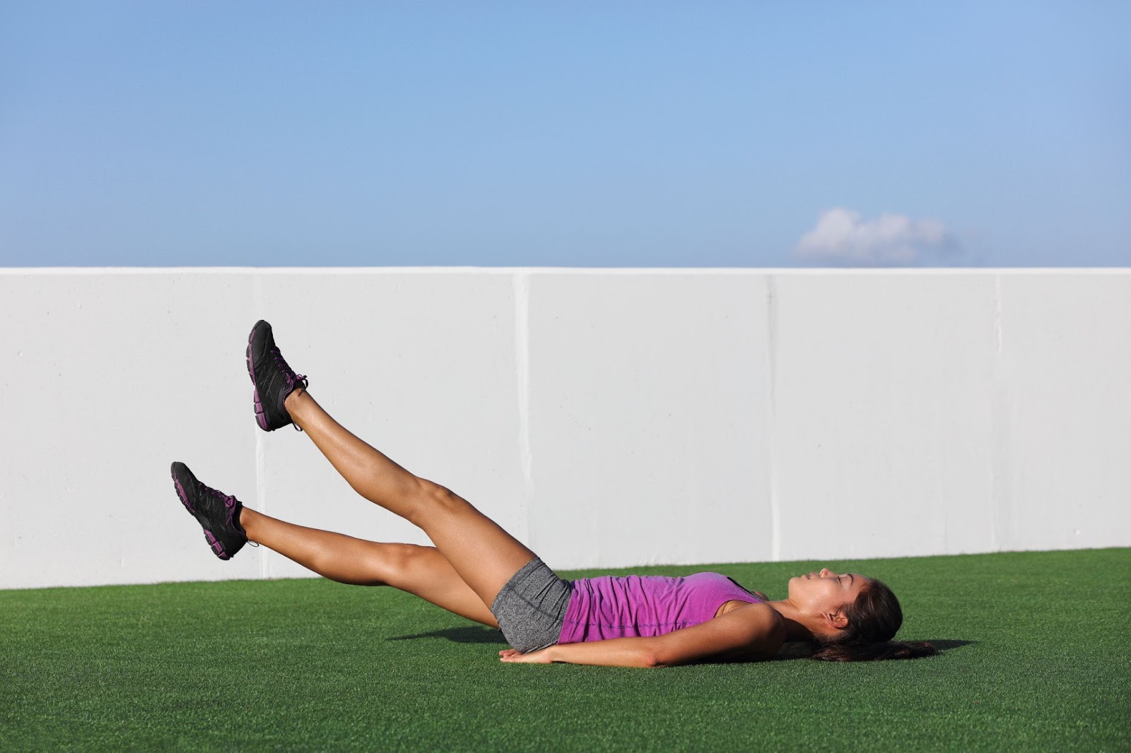 Woman outside performing a scissor kick