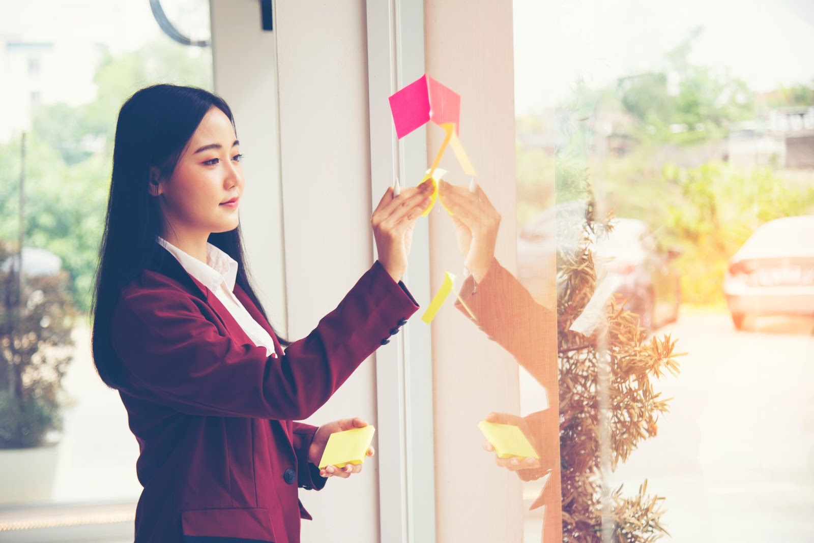 Woman putting up post-it notes for motivation at home