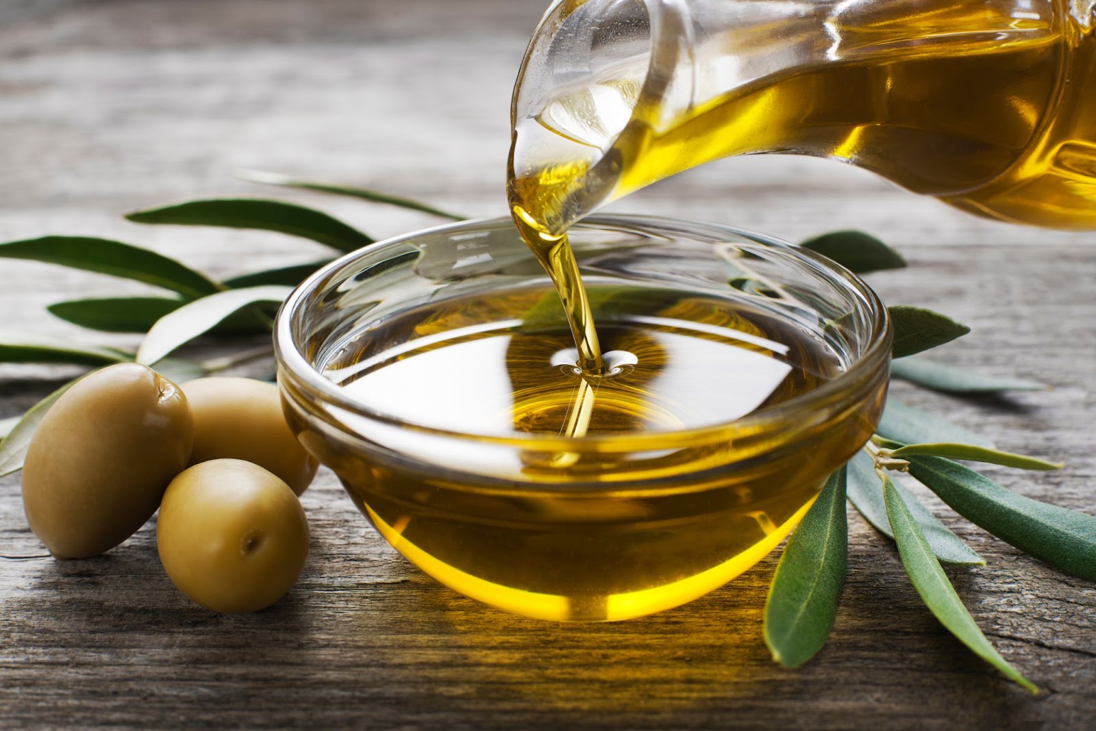 Image of olive oil being poured in a glass dish