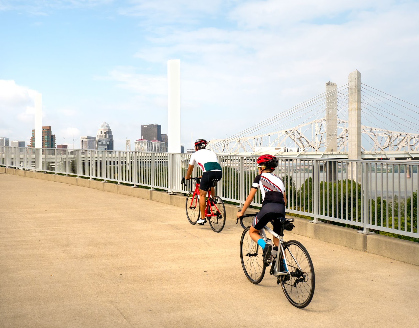 People riding on a Louisville urban bike path across a bridge