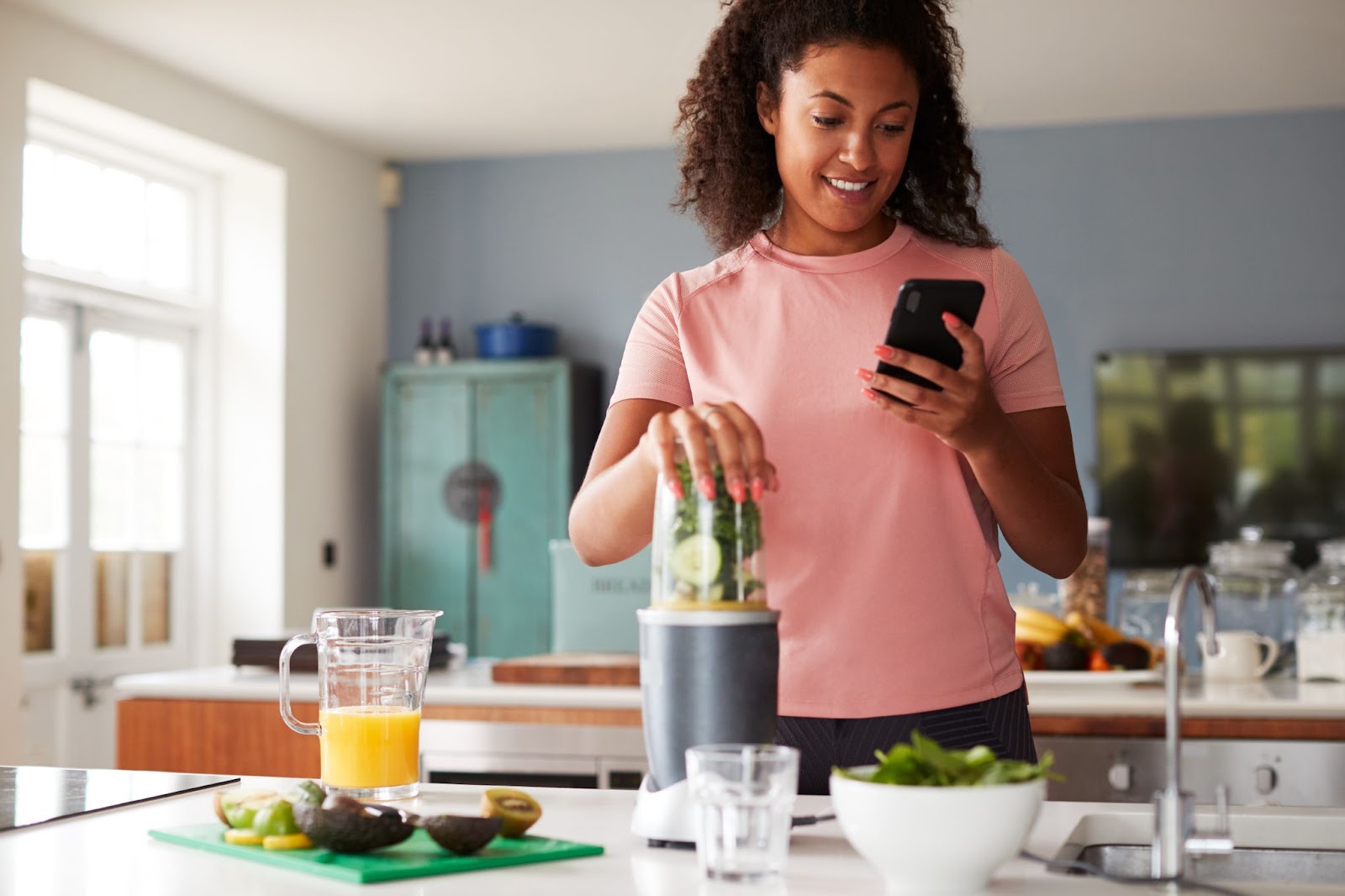 Woman using a fitness tracker to count the calories in her smoothie