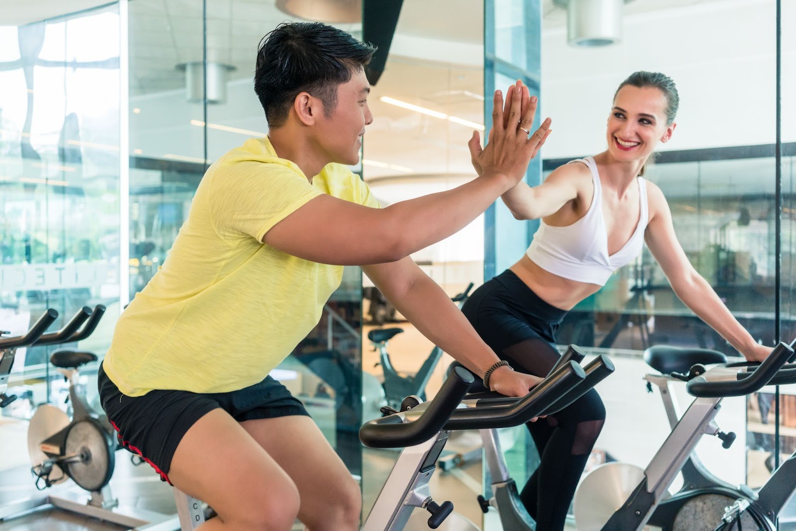 Man and woman high-fiving each other in Spin class