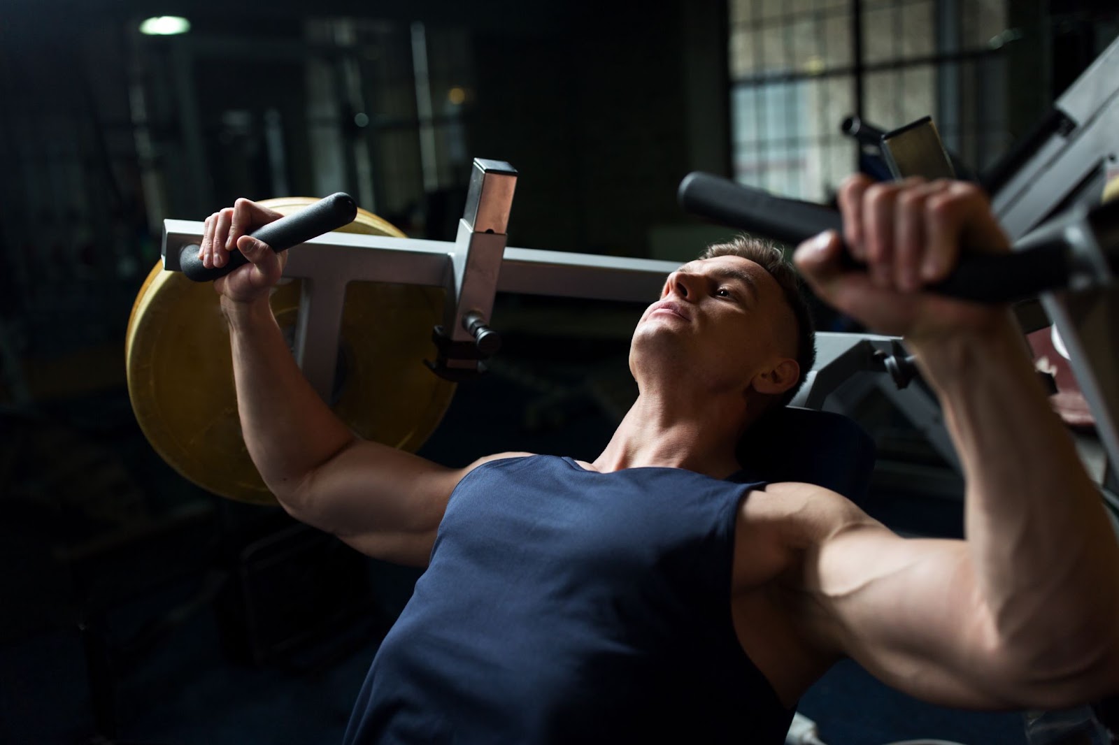 Fit man performing a chest press on a machine