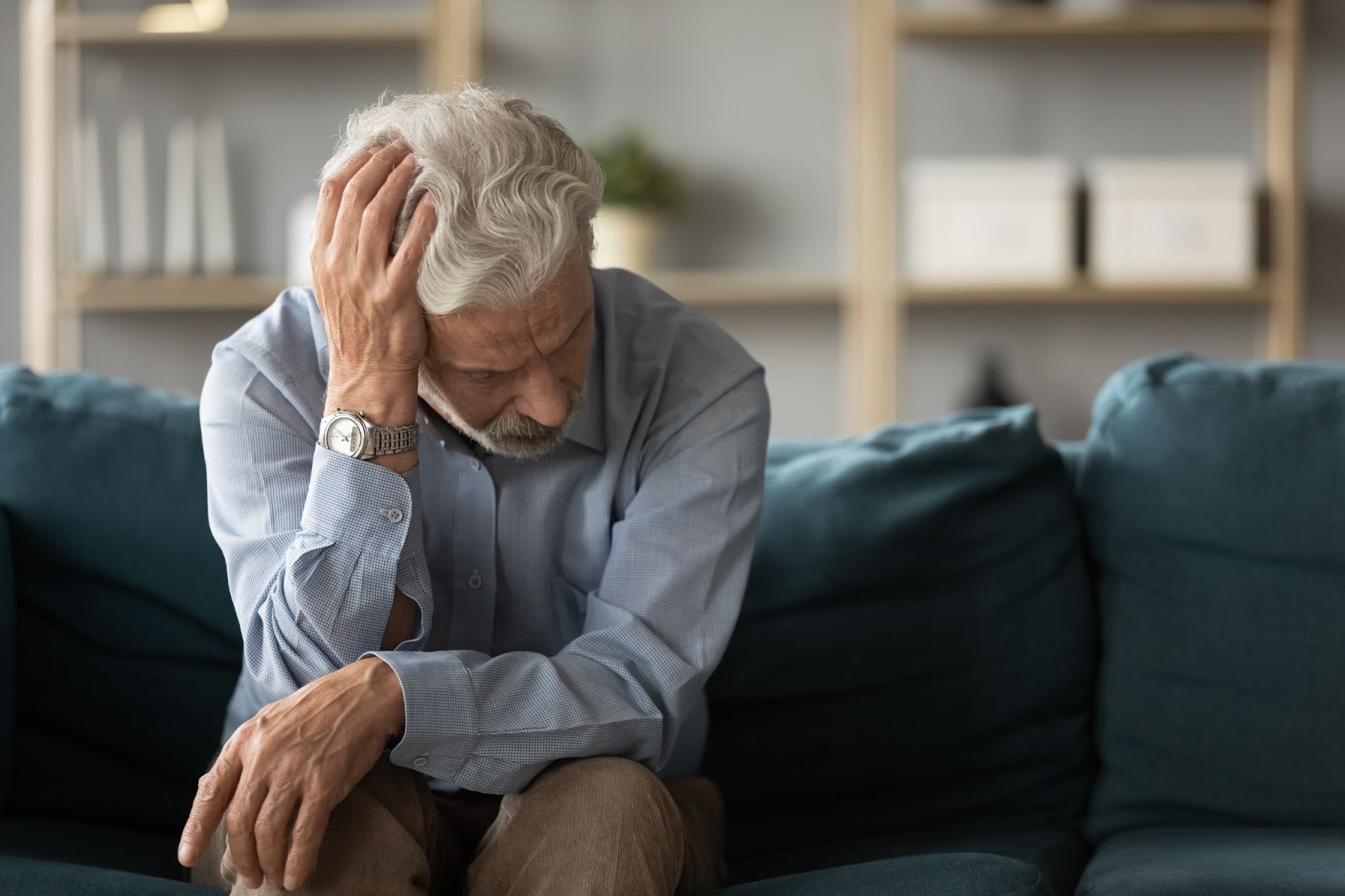 Older, white haired man, rubbing his head due to fatigue