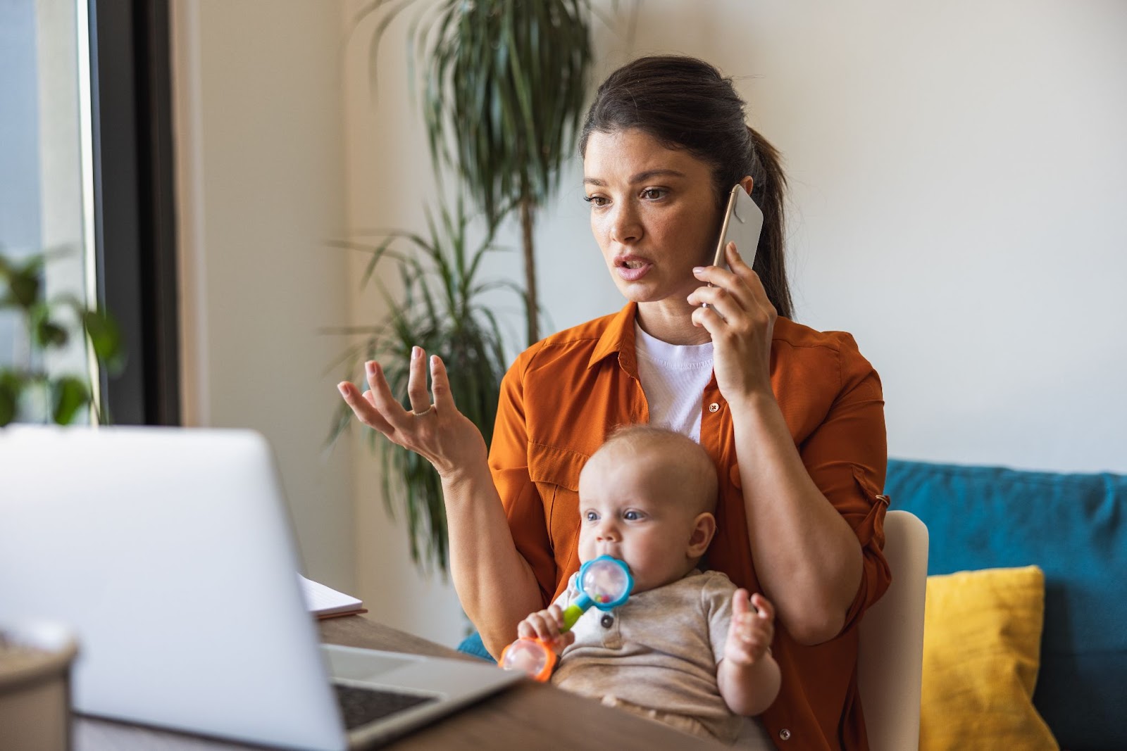 Busy mom at work with a baby on her lap