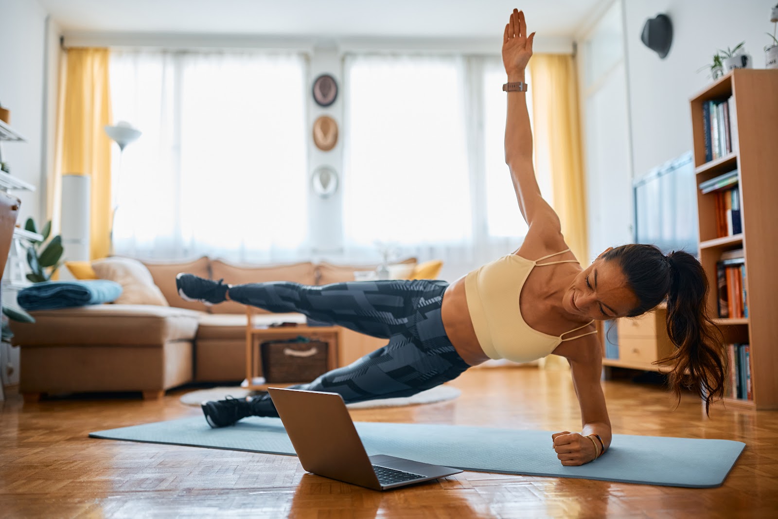 Fit woman performing a side plank with leg raise