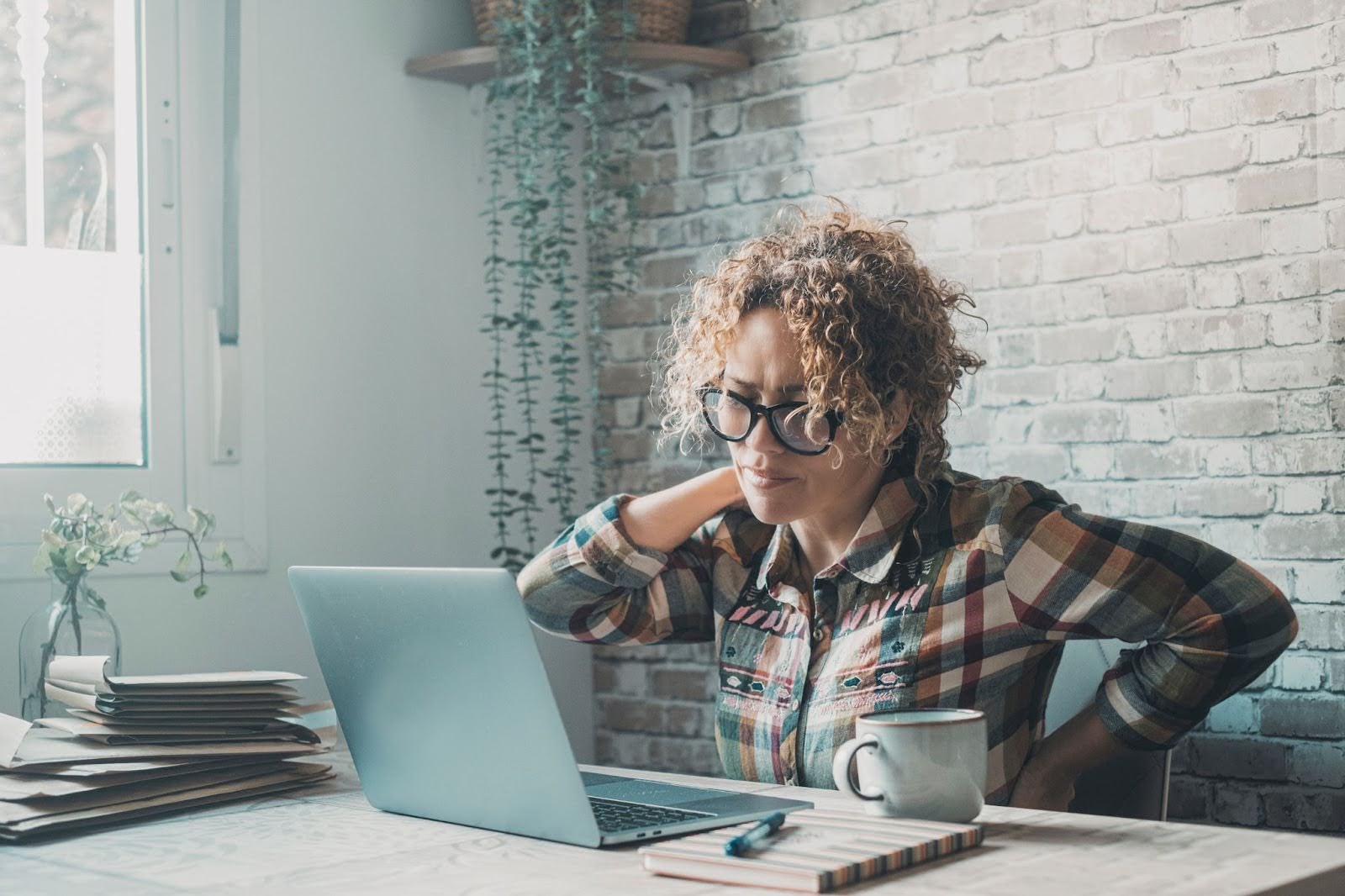 Women feeling overworked, with a sore neck at work