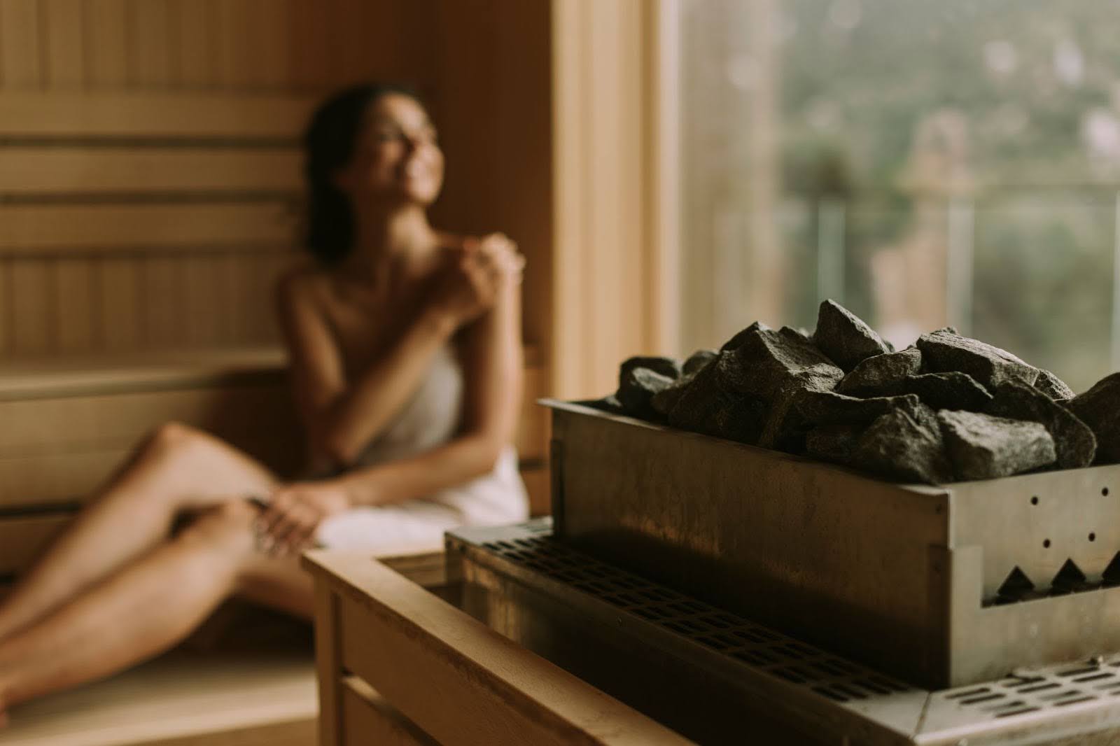 beautiful woman wearing a towel and sitting in a sauna