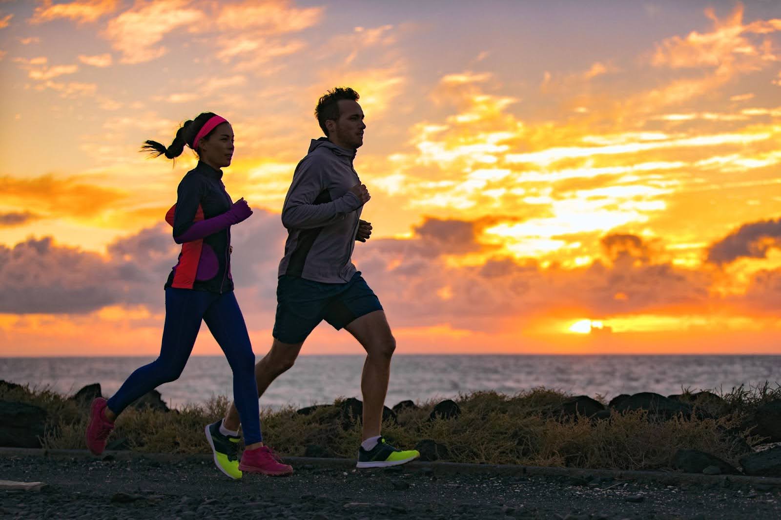 Fit couple going for a morning run together along the beach