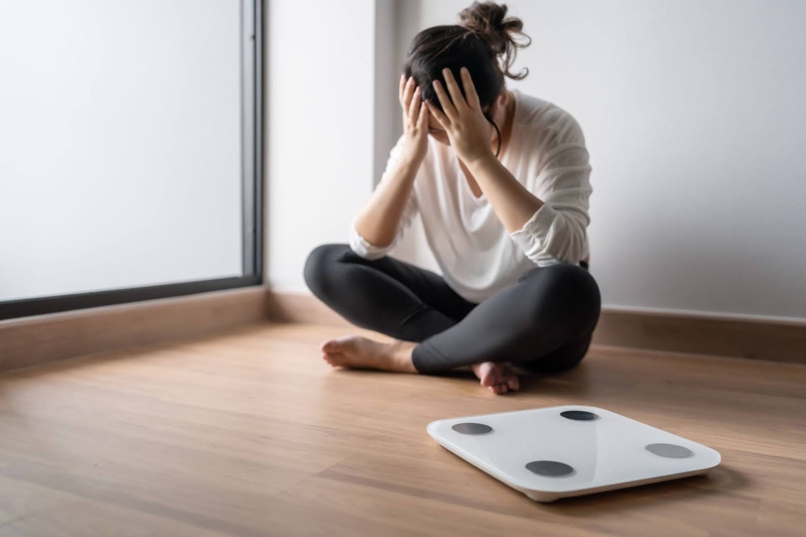 A person looking distraught at the thought of stepping on a scale